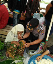 Terharu, Polisi Erisman Suapkan Nenek Renta Dekat Tumpukan Sayur Bekas
