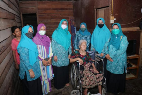 Ketua TP PKK Kabupaten Siak, Hj. Rasidah berfoto bersama pengurus TP PKK Siak dan warga penerima bantuan Berkah Ramadhan.