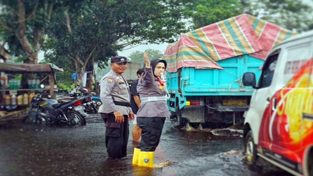 Meski Hujan Deras, Polwan Cantik Ini Atur Lalin Di Tengah Banjir Sambil Sosialisasi Pemilu Damai