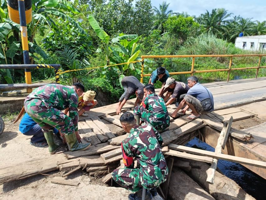 Empat Anggota Koramil 0321-05/ RM dan Warga Gotong Royong Perbaiki Jembatan Rusak